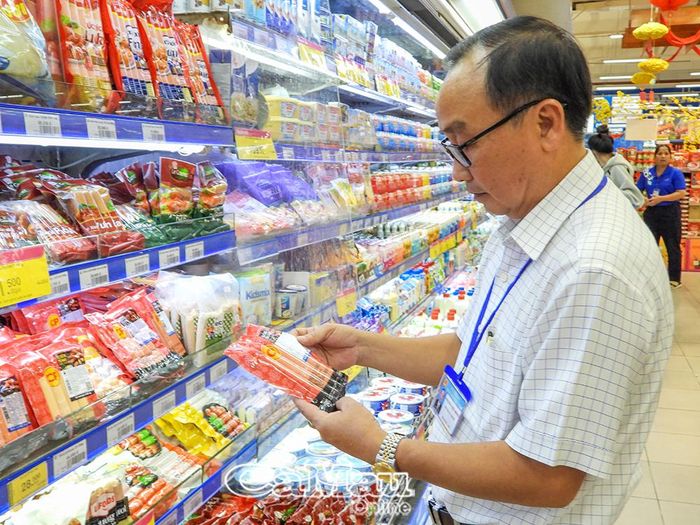 Kiểm tra hạn sử dụng và nơi sản xuất đối với thực phẩm được bày bán tại Co.opmart Cà Mau.
