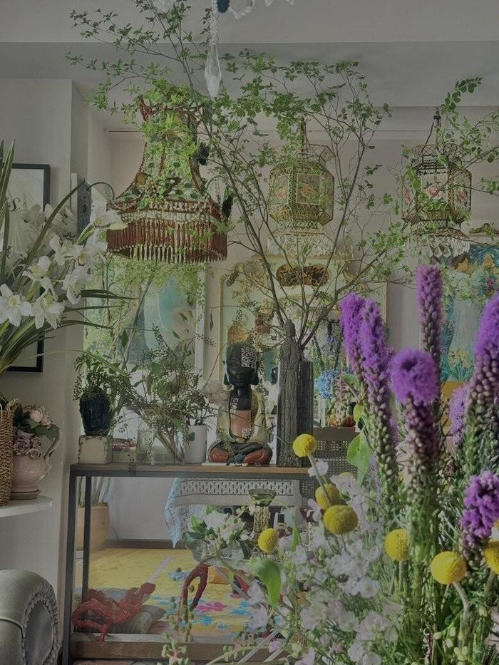 Góc nhìn từ xa bao quát, nơi sắc xanh của lá và sắc hoa rực rỡ hòa quyện cùng các bức tranh treo tường khổ lớn. Cách phối màu tương phản nhưng hài hòa giữa nội thất và hoa tươi khẳng định gu thẩm mỹ thượng lưu của cháu trai gia tộc Lý Quí.