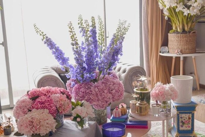 Góc nhỏ đầy nữ tính với những đóa hồng pastel dịu dàng đặt cạnh chiếc đèn tinh xảo, tạo điểm nhấn mềm mại cho không gian. Sự phối hợp giữa sắc tím của hoa phi yến vươn cao và sắc hồng của cẩm tú cầu tạo nên một góc nhìn đầy mê hoặc, thư thái.