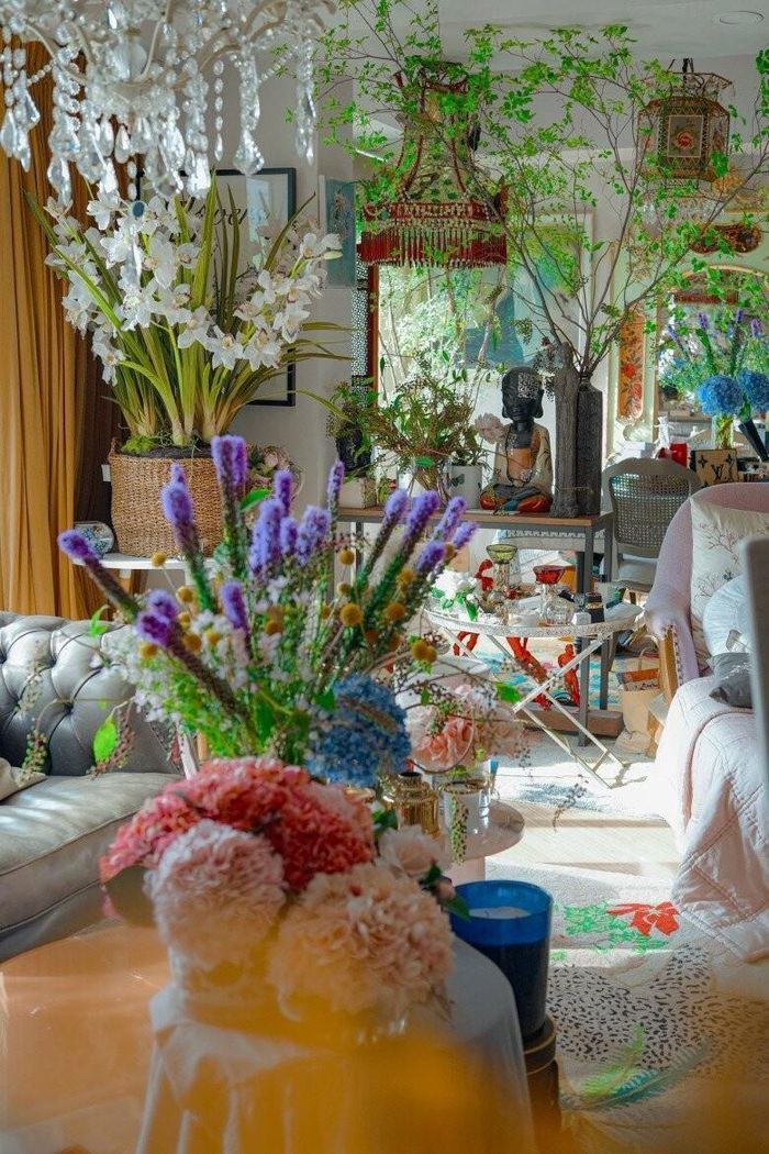 Ánh nắng ngập tràn chiếu rọi vào phòng khách, làm nổi bật những lẵng lan hồ điệp trắng tinh khôi phối cùng sắc tím oải hương lãng mạn. Từng món đồ decor từ đèn chùm pha lê đến tượng Phật đều được NTK sắp đặt tỉ mỉ, thể hiện cái tôi thẩm mỹ khác biệt.