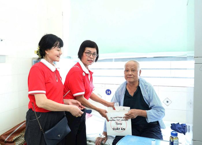 Hội viên Hội Chữ thập đỏ phường Phú Thượng trao quà cho bệnh nhân đang điều trị tại Bệnh viện K cơ sở Tân Triều. Ảnh: PT