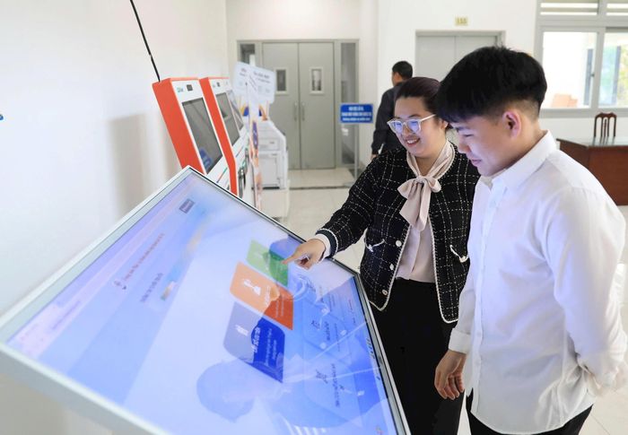 Hỗ trợ người dân giải quyết thủ tục hành chính trực tuyến tại Trung tâm Phục vụ hành chính công chi nhánh Cầu Giấy. Ảnh: Quang Thái