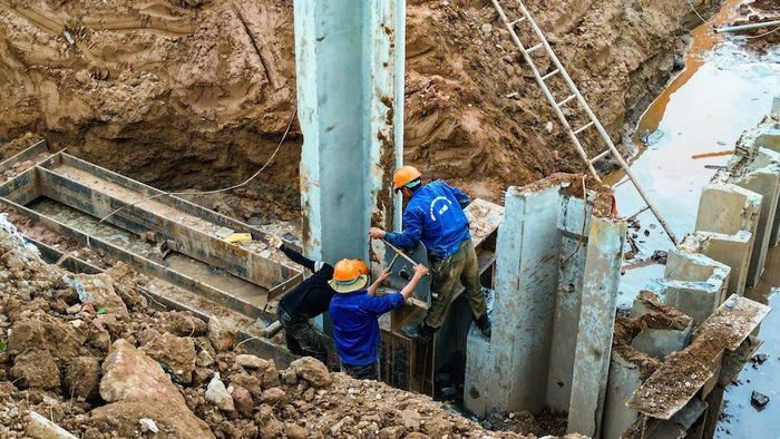 Công nhân và thiết bị cơ giới thi công trong lòng hồ điều hòa Mễ Trì - Đồng Bông 2, chuẩn bị hoàn thiện các hạng mục kè và tiêu thoát nước.