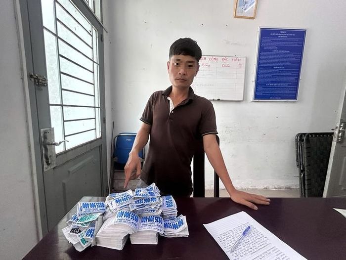 Nguyễn Văn T. cùng tờ cam kết và số quảng cáo chưa kịp dán
