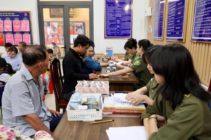 Cán bộ công an hỗ trợ phụ huynh kê khai thông tin để hoàn tất hồ sơ cấp căn cước cho trẻ em