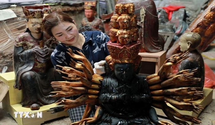 Nghệ nhân làng nghề Sơn Đồng hoàn thiện sản phẩm. (Ảnh: TTXVN phát)