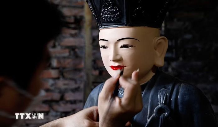 Nghệ nhân làng nghề Sơn Đồng hoàn thiện sản phẩm. (Ảnh: TTXVN phát)