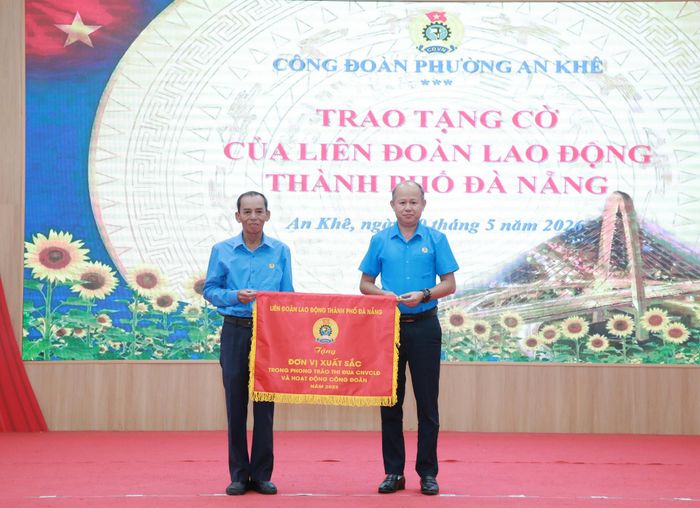 Đại diện lãnh đạo Liên đoàn Lao động thành phố Đà Nẵng (bên phải) trao cờ thi đua cho tập thể xuất sắc thuộc Công đoàn phường An Khê. Ảnh: ĐẮC MẠNH
