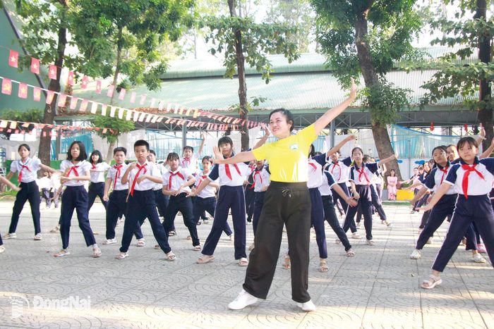Bà Phạm Thị Ngọc Hà, Chủ tịch Liên đoàn thể dục thành phố Đồng Nai cùng học sinh Trường Tiểu học Phan Chu Trinh (phường Tân Triều) nhảy dân vũ trên nền nhạc của bài hát Thành phố Đồng Nai vươn cao khát vọng. Ảnh: Nga Sơn