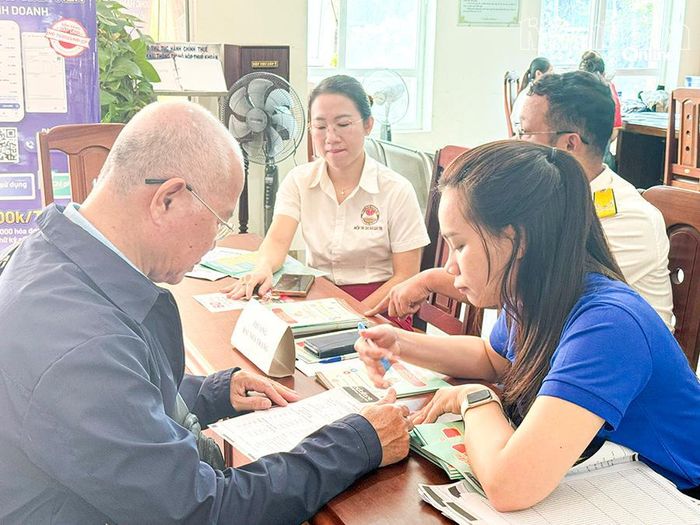 Cán bộ thuế tuyên truyền, hướng dẫn chính sách thuế cho người dân.