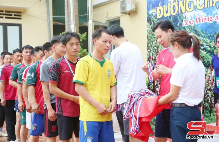 Ban tổ chức trao kỷ niệm chương cho các VĐV tham gia giải chạy.