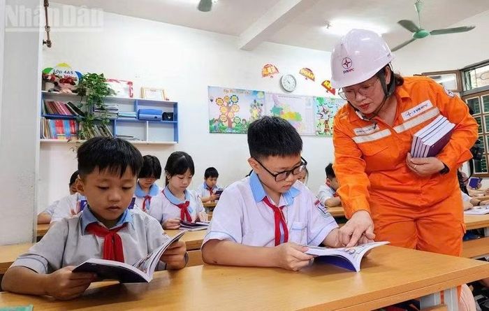 Cán bộ Công ty Điện lực Sơn La trao tặng sách và hướng dẫn các em tìm hiểu các nội dung trong sách thiếu nhi “Bí mật quả cầu tím”.