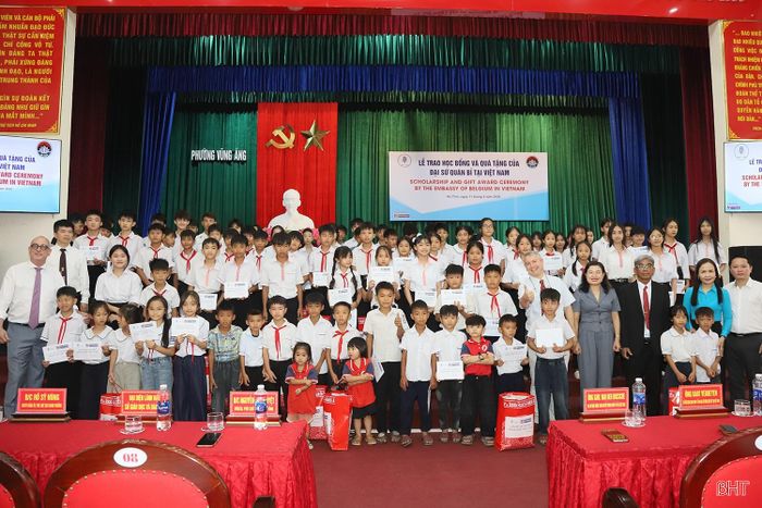  Đoàn công tác Đại sứ quán Vương quốc Bỉ chụp ảnh lưu niệm cùng lãnh đạo tỉnh, địa phương và các em học sinh phường Vũng Áng. 