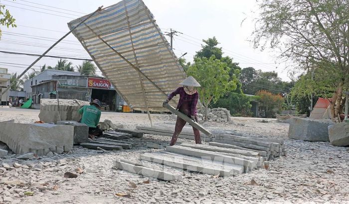 "Công xưởng" chẻ đá của vợ chồng Anh Tâm chỉ là một chiếc bạt đã phai màu, sờn rách, bên dưới ngổn ngang đá lớn, đá nhỏ. Ảnh: Công Mạo - TTXVN