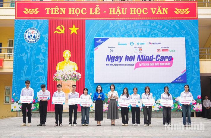 Các đại biểu trao học bổng khuyến khích học tập cho các em học sinh Trường THPT Hoa Lư A.