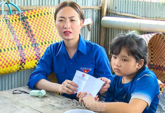 Chị Nguyễn Thị Hồng Diễm, Bí thư Xã đoàn Vĩnh Phước, trao tiền hỗ trợ lần hai cho em Lê Thị Anh Thi.