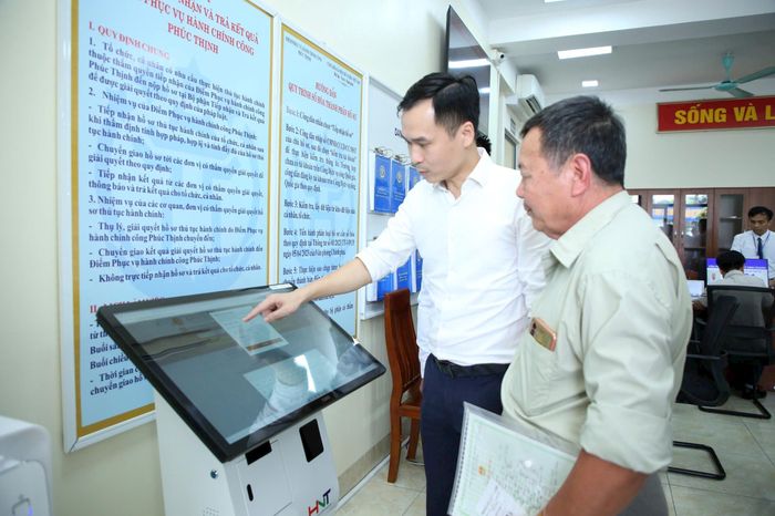 Hướng dẫn người dân làm thủ tục hành chính tại xã Phúc Thịnh, Hà Nội. Ảnh: Phạm Hùng