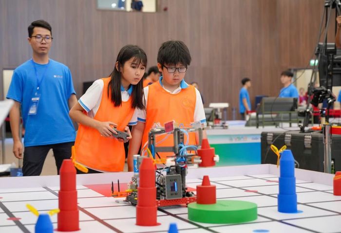 Nữ sinh chăm chú kiểm tra robot trước giờ thi đấu. (Ảnh: TPO)