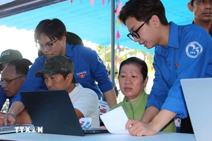 Thanh niên giúp người dân đăng ký các ứng dụng số. (Ảnh: Phan Sáu/TTXVN)