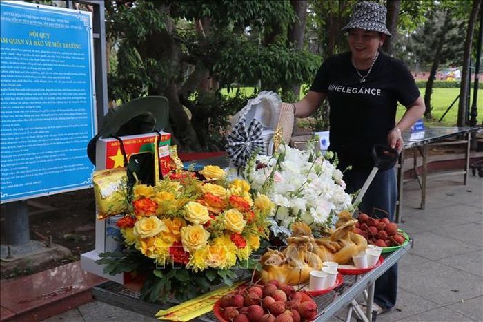 Chị Lê Thị Bích Liễu, chủ hộ kinh doanh dịch vụ, Cửa hàng đồ lễ Đông Dương, đặc khu Côn Đảo chuẩn bị mâm lễ xanh gồm hoa tươi, trái cây, vật phẩm thân thiện môi trường cho khách dâng cúng tại Nghĩa trang Hàng Dương, Côn Đảo. Ảnh: Thanh Vũ/TTXVN