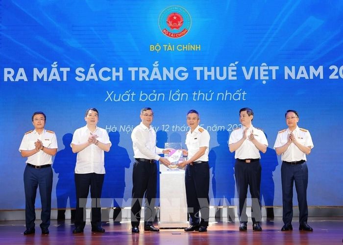 Bộ trưởng Bộ Tài chính Ngô Văn Tuấn trao Sách trắng Thuế Việt Nam 2026 cho Cục trưởng Cục Thuế Mai Xuân Thành. Ảnh: Phạm Hậu - TTXVN