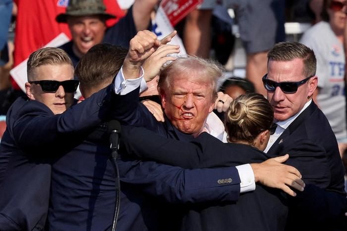 Bức ảnh ứng viên tổng thống Donald Trump giơ nắm đấm kiên cường sau vụ ám sát hụt hôm 13/7/2024. Ảnh: REUTERS
