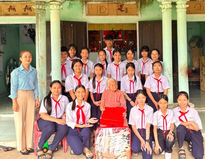 Học sinh, đội viên Trường THCS Đinh Châu (phường Điện Bàn Đông) đến thăm, trò chuyện, tặng quà Bà mẹ Việt Nam anh hùng Kiều Thị Thể. Ảnh: MẾN NGUYỄN