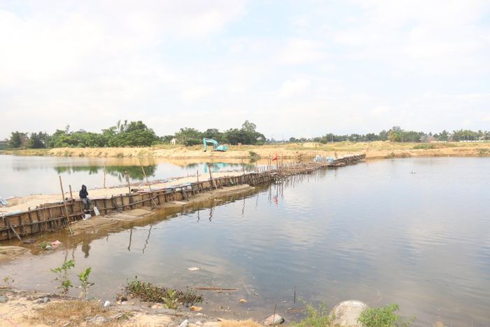 Tuyến đập tạm ngăn mặn, giữ ngọt trên sông Vĩnh Điện đang chờ được hàn khẩu, đắp hoàn thành. Ảnh: HOÀNG HIỆP