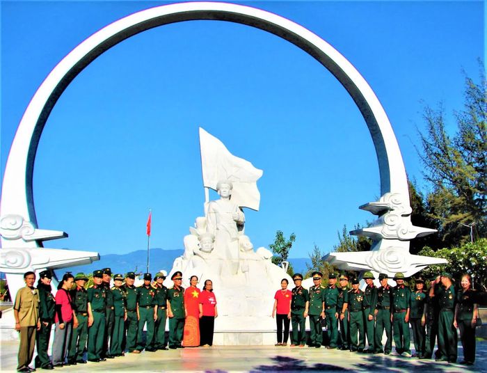 Đoàn cựu chiến binh chụp ảnh lưu niệm tại khu vực tượng đài Những người nằm lại phía chân trời.