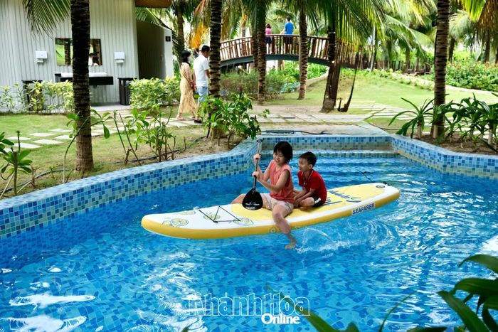Du khách nhí vui chơi tại hồ bơi trong khuôn viên Arena Resort Cam Ranh, một trong những điểm lưu trú thu hút nhiều gia đình trong mùa du lịch hè tại Bãi Dài.