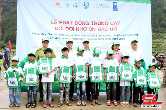 Các đại biểu trao quà cho các em học sinh có hoàn cảnh khó khăn Trường THCS xã Ngọc Chiến.