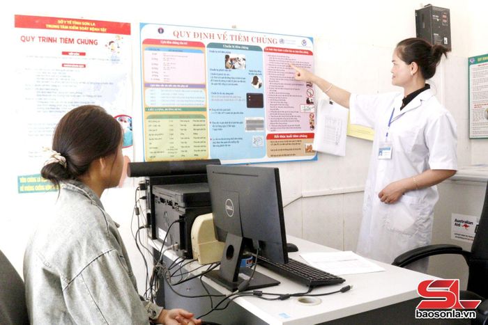 Cán bộ Trạm Y tế xã Chiềng Mai hướng dẫn người dân quy trình tiêm chủng.