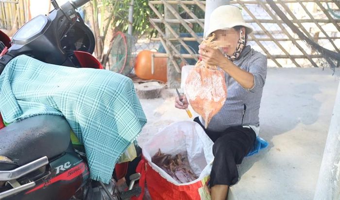 Một người hàng rong bán mực trước hàng quán khu vực biển Lăng Cô