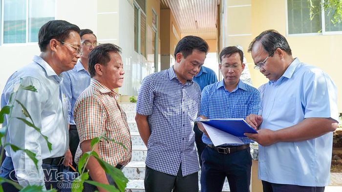  Đồng chí Nguyễn Minh Luân xem phương án quy hoạch xây dựng Trạm Y tế Xã Phan Ngọc Hiển.