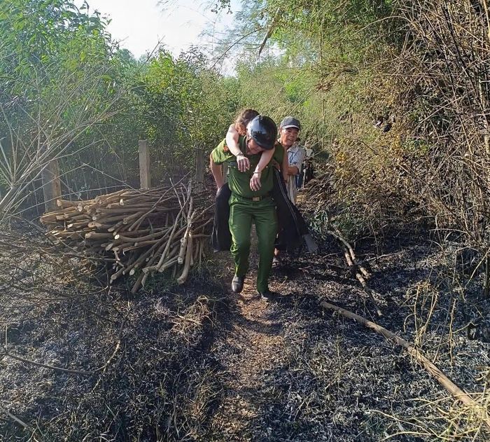 Cán bộ Công an xã Thu Bồn kịp thời hỗ trợ, đưa nạn nhân bị ngạt khói đi cấp cứu.