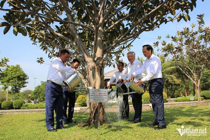 Các đại biểu tưới nước chăm sóc cây da búp đỏ do ông Nguyễn Hòa Bình trồng lưu niệm trước đó tại Quần thể tượng đài Mẹ Việt Nam anh hùng