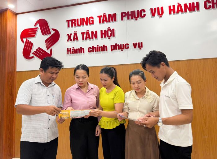 Trưởng phòng Văn hóa - Xã hội xã Tân Hội Hồ Anh Tuấn (bìa trái) tuyên truyền, vận động người dân tham gia bảo hiểm y tế, bảo hiểm xã hội tự nguyện.