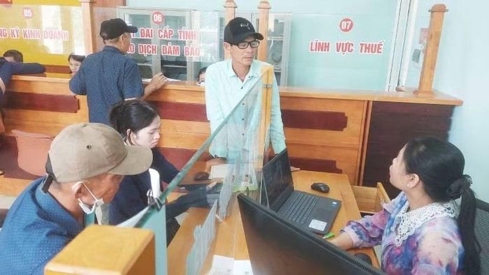 Cán bộ xã Đông Trạch, tỉnh Quảng Trị trao đổi, hướng dẫn về thủ tục hành chính cho người dân.