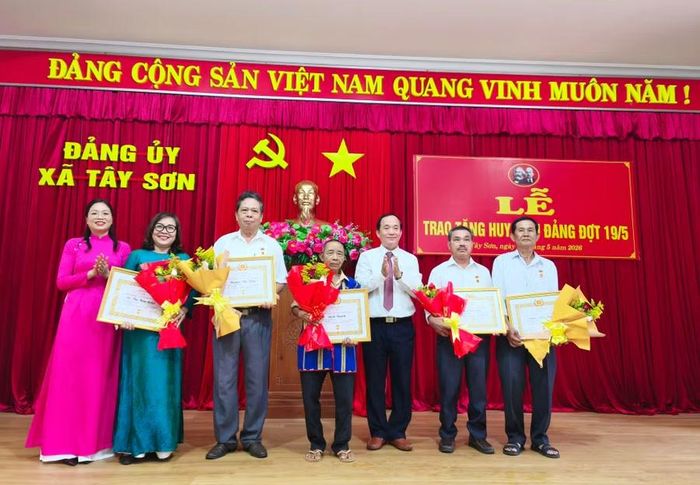  Đảng bộ ủy Tây Sơn trao tặng huy hiệu Đảng cho 21 đảng viên. Ảnh: Đinh Ngọc 