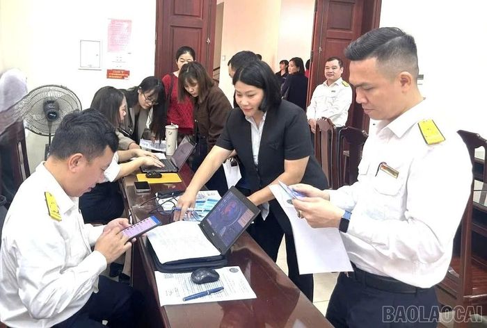 Cán bộ thuế tháo gỡ vướng mắc cho các hộ kinh doanh trong kê khai thuế.