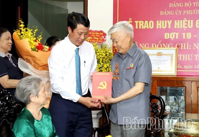 Đồng chí Trưởng Ban Tổ chức Tỉnh ủy Bùi Đình Thi tặng quà cho đồng chí Nguyễn Hữu Điền.
