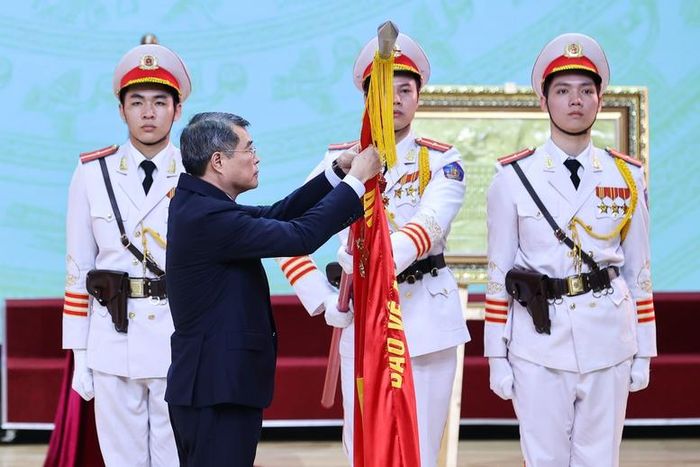 Thủ tướng Lê Minh Hưng gắn Danh hiệu Anh hùng Lực lượng vũ trang nhân dân lên Cờ truyền thống của Công an TP. Hải Phòng. Ảnh: CP