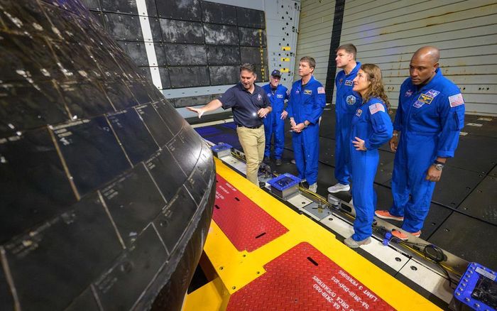Kỹ sư NASA cùng phi hành đoàn Artemis II kiểm tra tấm chắn nhiệt của tàu Orion, ít tuần sau khi trở về Trái Đất. (Ảnh: NASA)