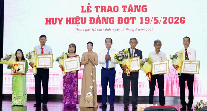 Phó Bí thư Đảng ủy UBND TPHCM Huỳnh Tân Định, Phó Trưởng Ban Tuyên giáo và Dân vận Thành ủy TPHCM Lê Thị Thủy trao Huy hiệu Đảng đến đảng viên. Ảnh: NGÔ BÌNH