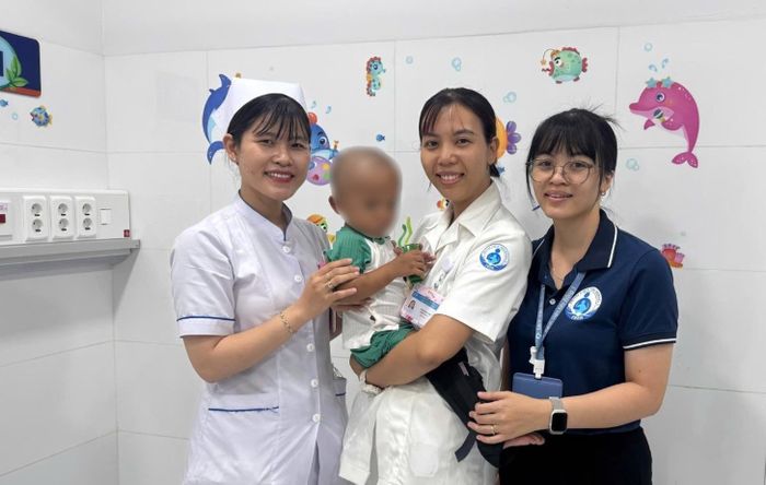 Bé N.G.K. và các y bác sĩ Bệnh viện Nhi đồng 1 trước khi xuất viện.
