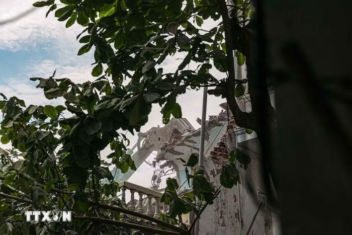 Máy xúc phá dỡ một công trình nằm sâu trong khu dân cư trên phố Nguyễn Trãi. (Ảnh: Phạm Tuấn Anh/TTXVN)
