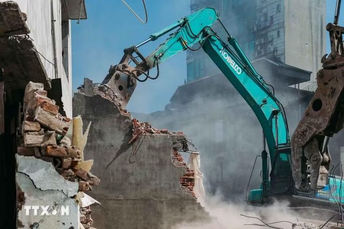 Máy xúc phá vỡ từng mảng tường bêtông trong quá trình tháo dỡ công trình cũ. (Ảnh: Phạm Tuấn Anh/TTXVN)