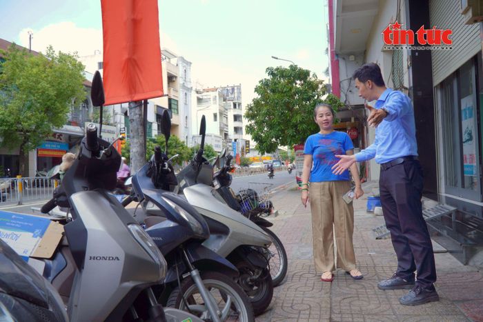 Anh Lương Quang Nhật Minh, chuyên viên Phòng Kinh tế, Hạ tầng và Đô thị (UBND phường An Đông) hướng dẫn hộ kinh doanh bố trí khu vực để xe trên vỉa hè sau khi đăng ký sử dụng.