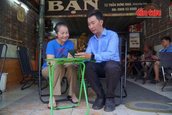 Bà Lê Thị Yến Vân, hộ kinh doanh trên đường Trần Hưng Đạo, được hướng dẫn sử dụng ứng dụng đăng ký vỉa hè trực tuyến.