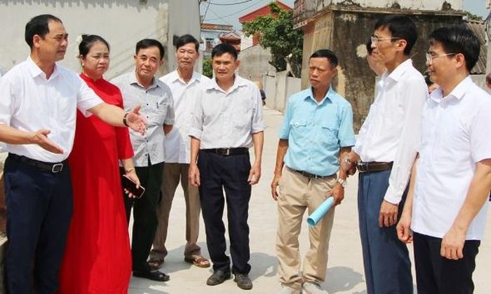 Đồng chí Nguyễn Huy Ngọc, Bí thư Đảng ủy xã Phúc Hòa (ngoài cùng bên trái) trao đổi về kinh nghiệm mở rộng đường thôn.
